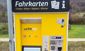 gelb-grauer Fahrscheinautomat an einer Haltestelle im Grünen (Foto: DB)