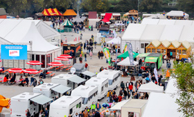 Luftaufnahme der Heilbronner Herbstmesse 2022: Besucher flanieren zwischen Messezelten und Außenständen.
