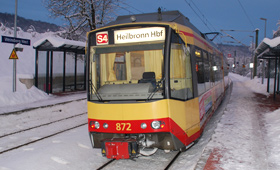 Stadtbahnfahrzeug an winterlich verschneiter Haltestelle