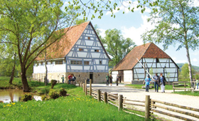 Von Bäumen eingerahmte historische Fachwerkhäuser im Hohenloher Freilandmuseum Wackershofen. 